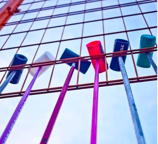 bike polo mallets hang from a fence